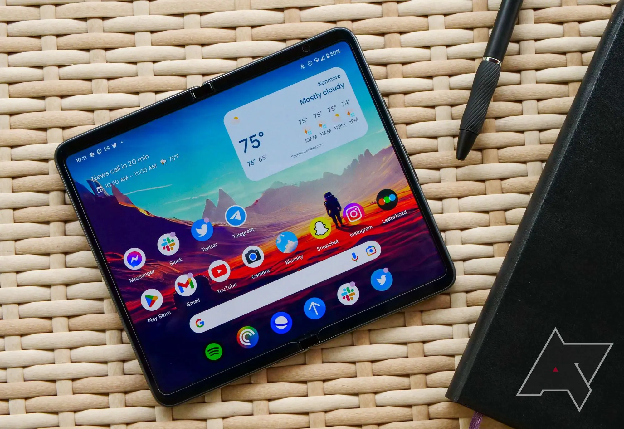 Điện thoại Google Pixel Fold đặt trên bàn mây tre, thể hiện thiết bị sau một thời gian sử dụng