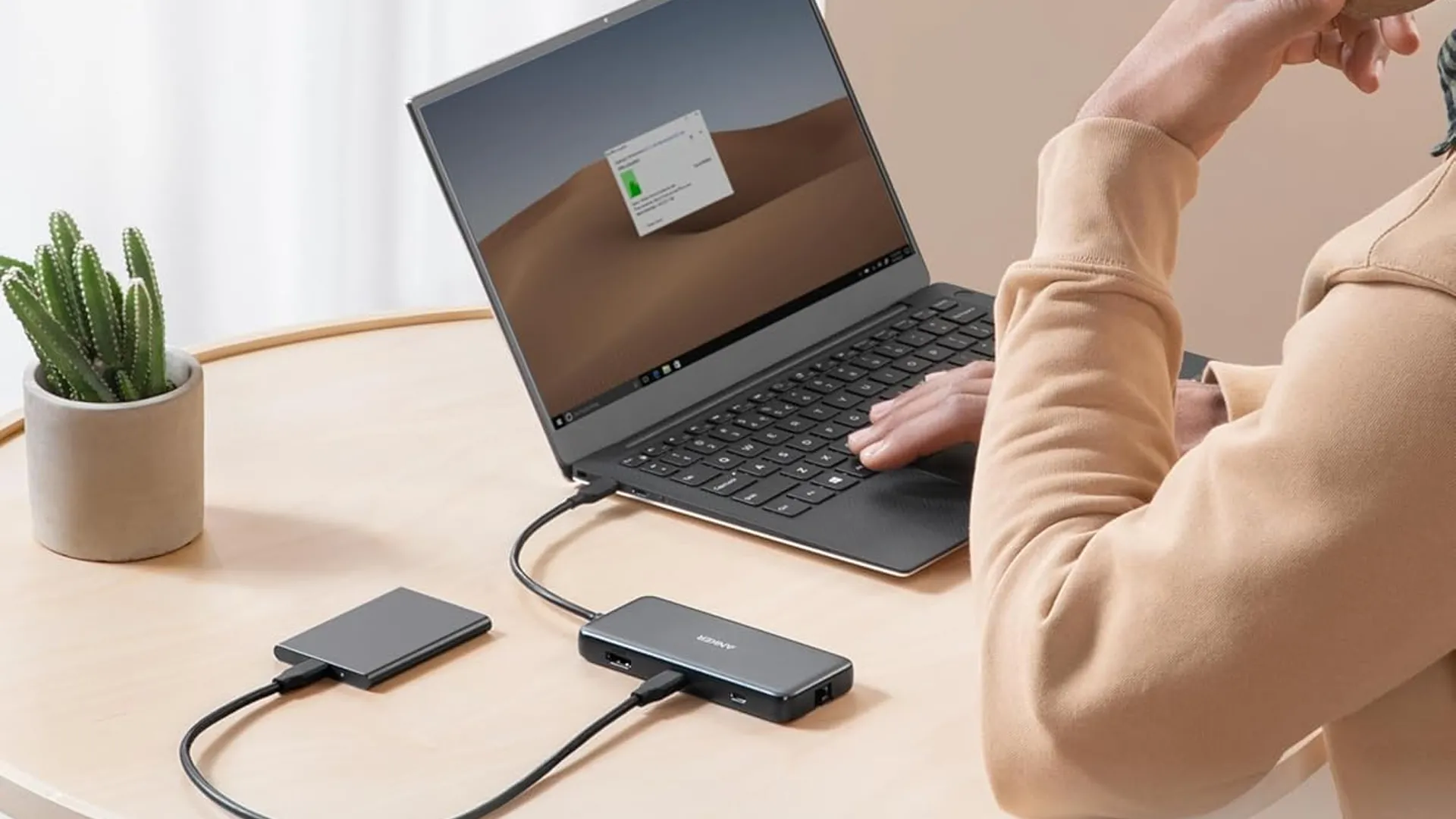 Hub Anker 555 8-in-1 USB-C đặt trên bàn và cắm vào laptop, minh họa khả năng mở rộng kết nối cho các thiết bị di động.