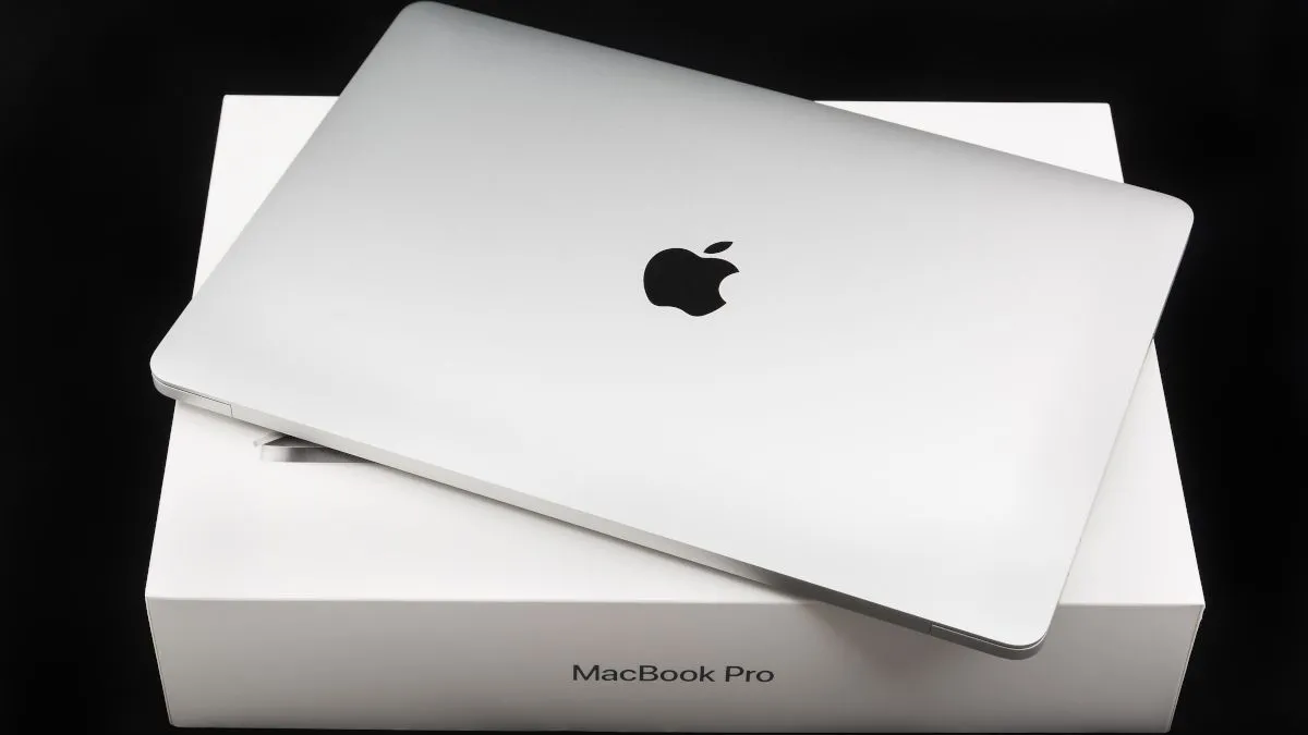 MacBook Pro màu bạc đặt trên hộp đựng gốc, thể hiện việc giữ gìn bao bì
