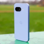 Mặt lưng màu tím nổi bật của điện thoại Google Pixel 9a đặt trong công viên.