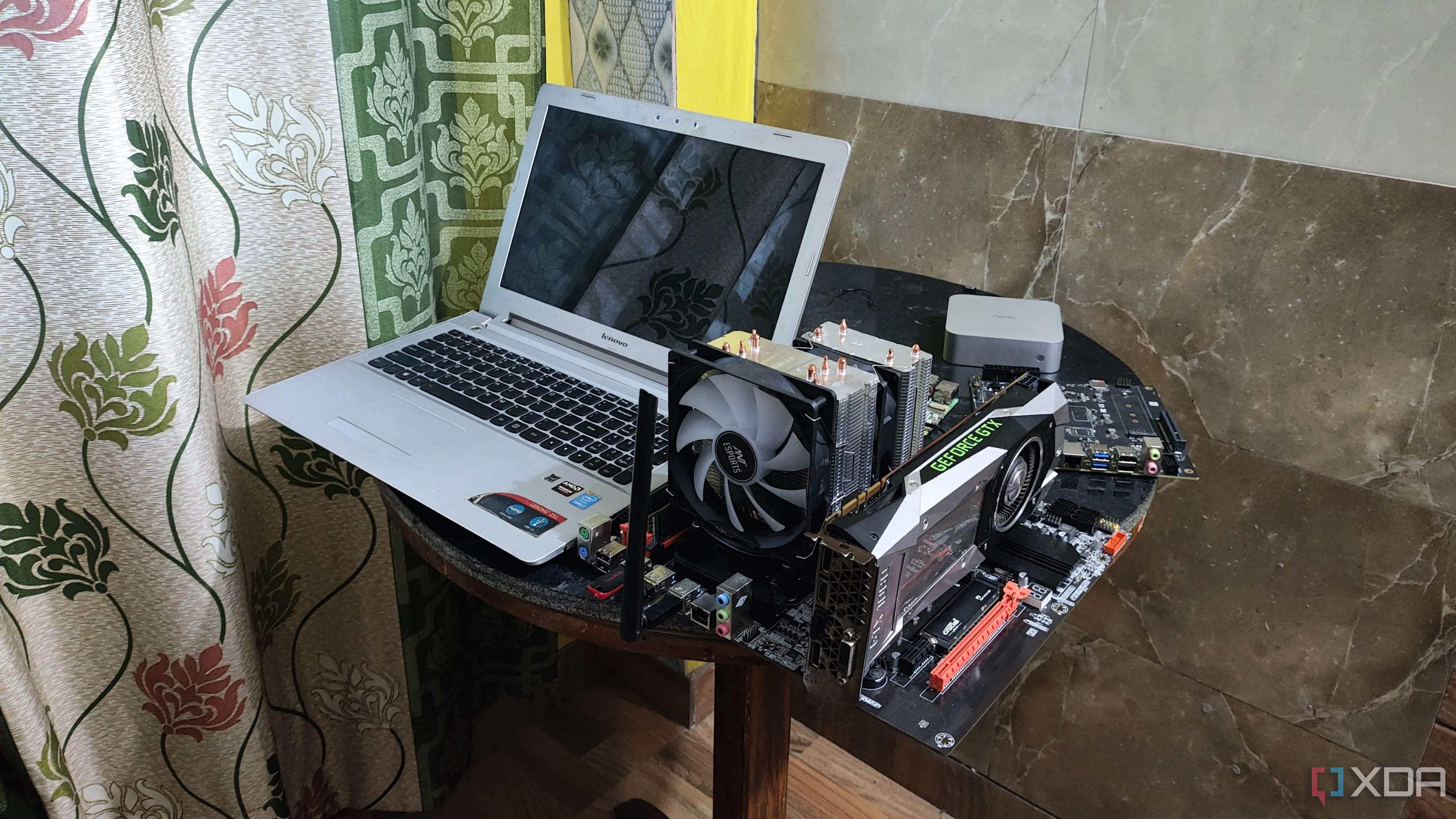 Một chiếc laptop Lenovo cũ đặt cạnh một case máy chủ, minh họa việc tận dụng laptop làm home server