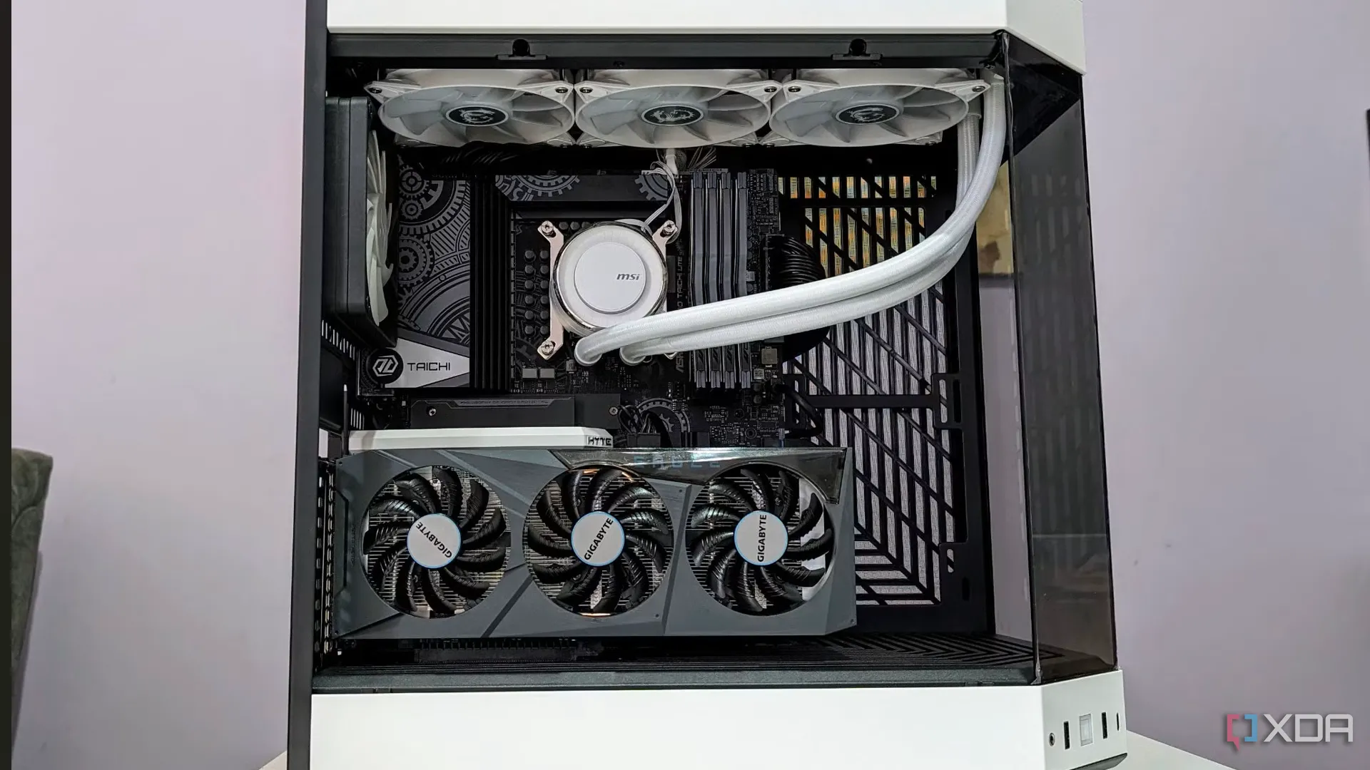 Ảnh chụp một bộ PC đã hoàn thiện bên trong vỏ case màu trắng với mặt kính bên hông mở ra, hiển thị rõ các linh kiện