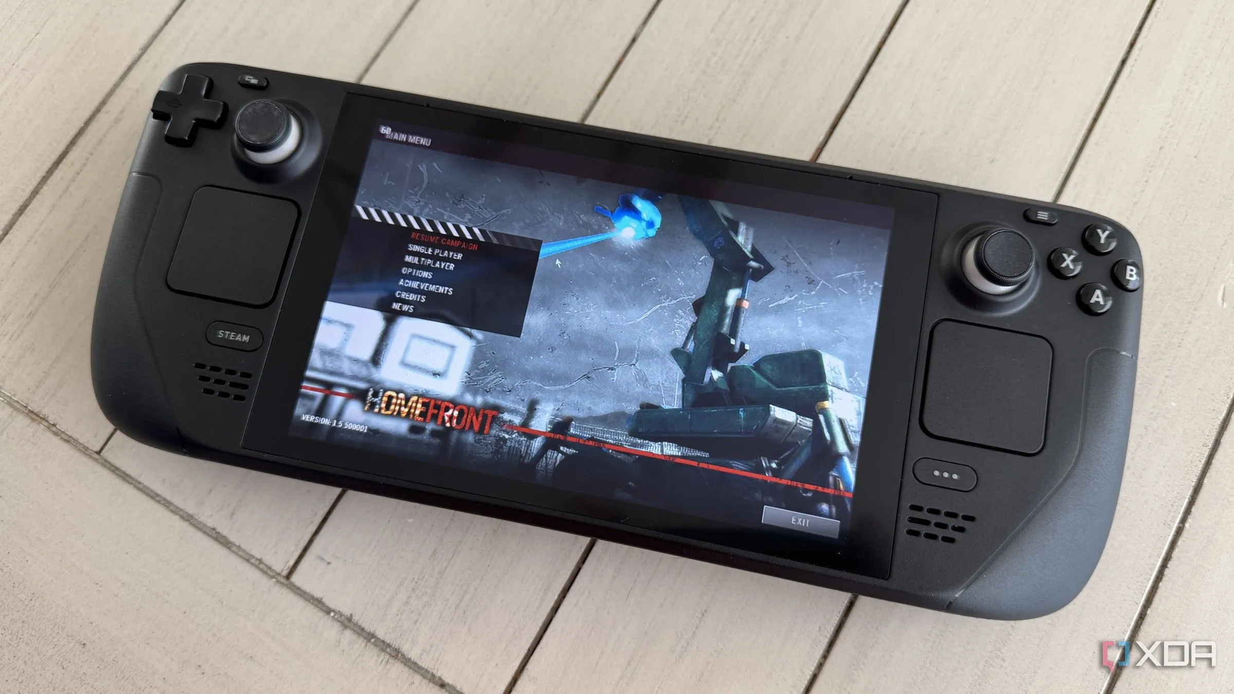 Bàn phím và tay cầm chơi game Steam Deck trên bàn với game Homefront đang chạy, minh họa việc chơi game PC.