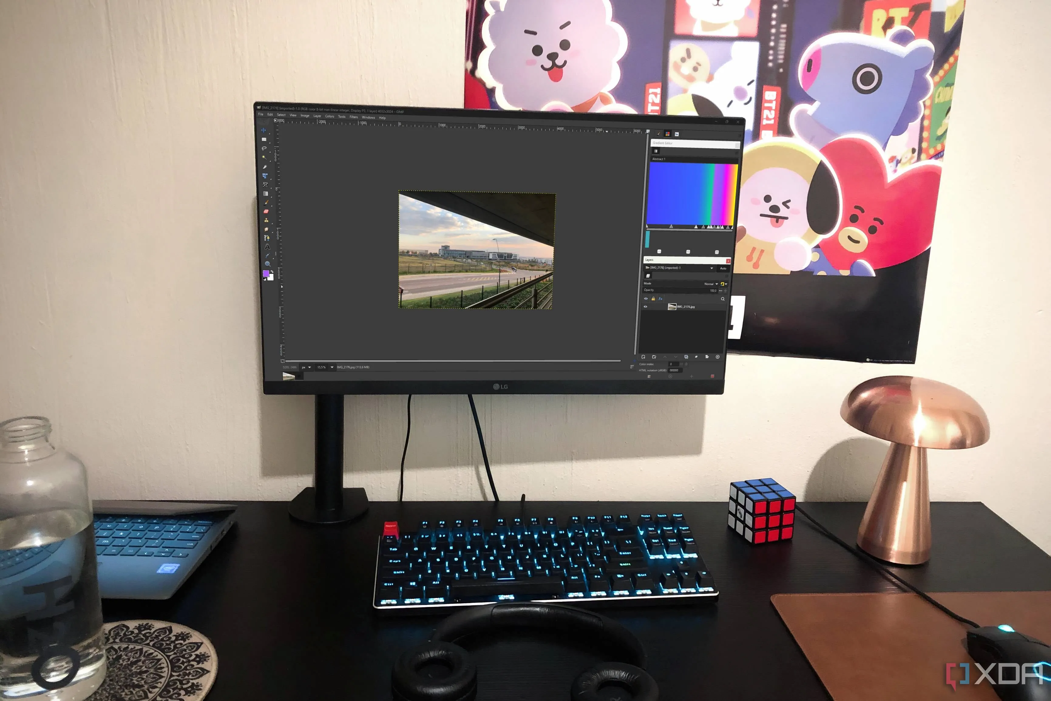 Bố cục tùy chỉnh của GIMP trên PC để bàn, cùng với đèn, áp phích, Chromebook và chai nước