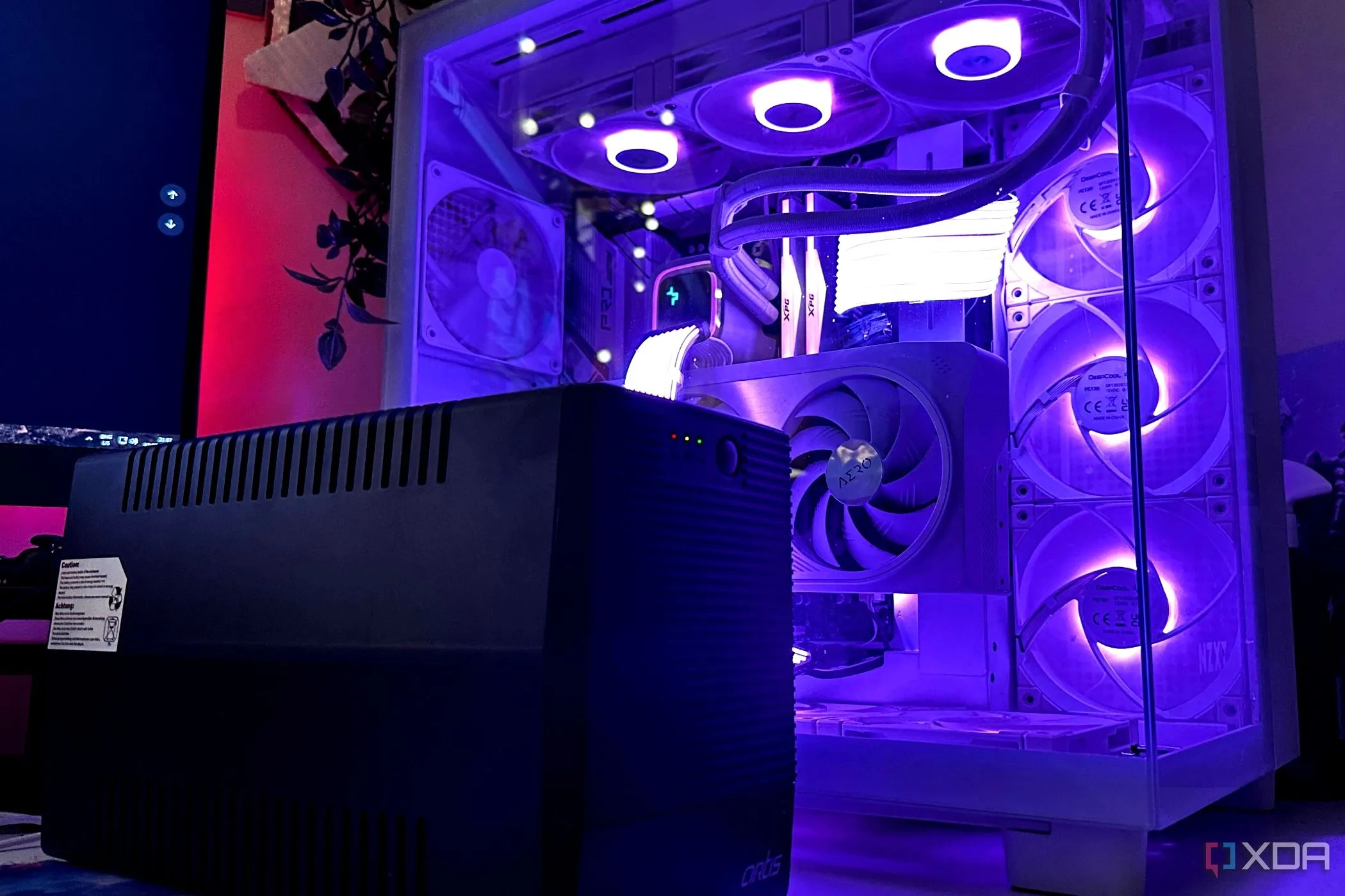 Bộ lưu điện UPS màu đen đặt cạnh thùng máy tính gaming để bảo vệ thiết bị khỏi sự cố điện