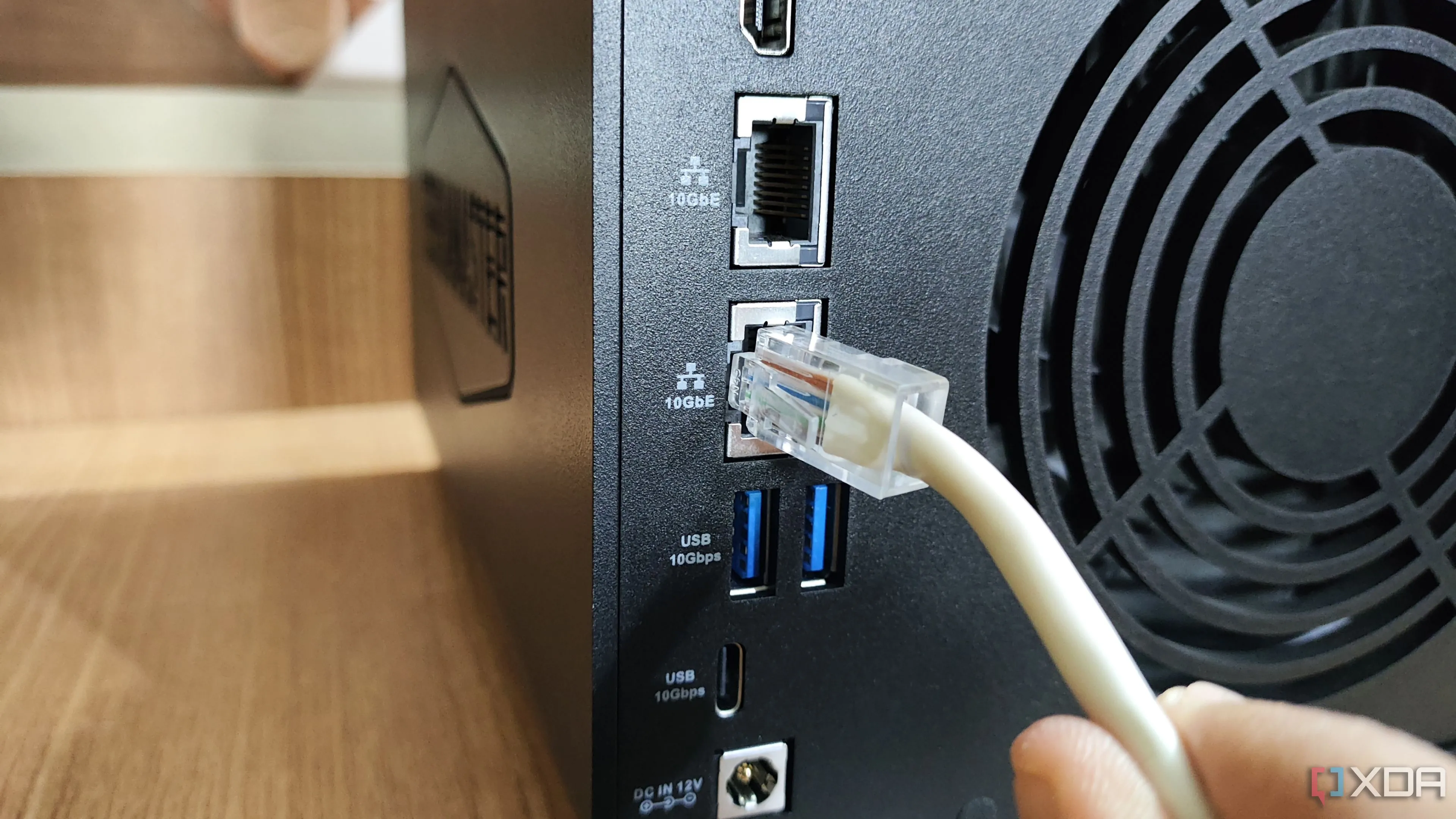 Cắm cáp Ethernet vào cổng LAN 10GbE của thiết bị NAS TerraMaster F4-424 Max, nhấn mạnh sự ổn định và đáng tin cậy của kết nối có dây.