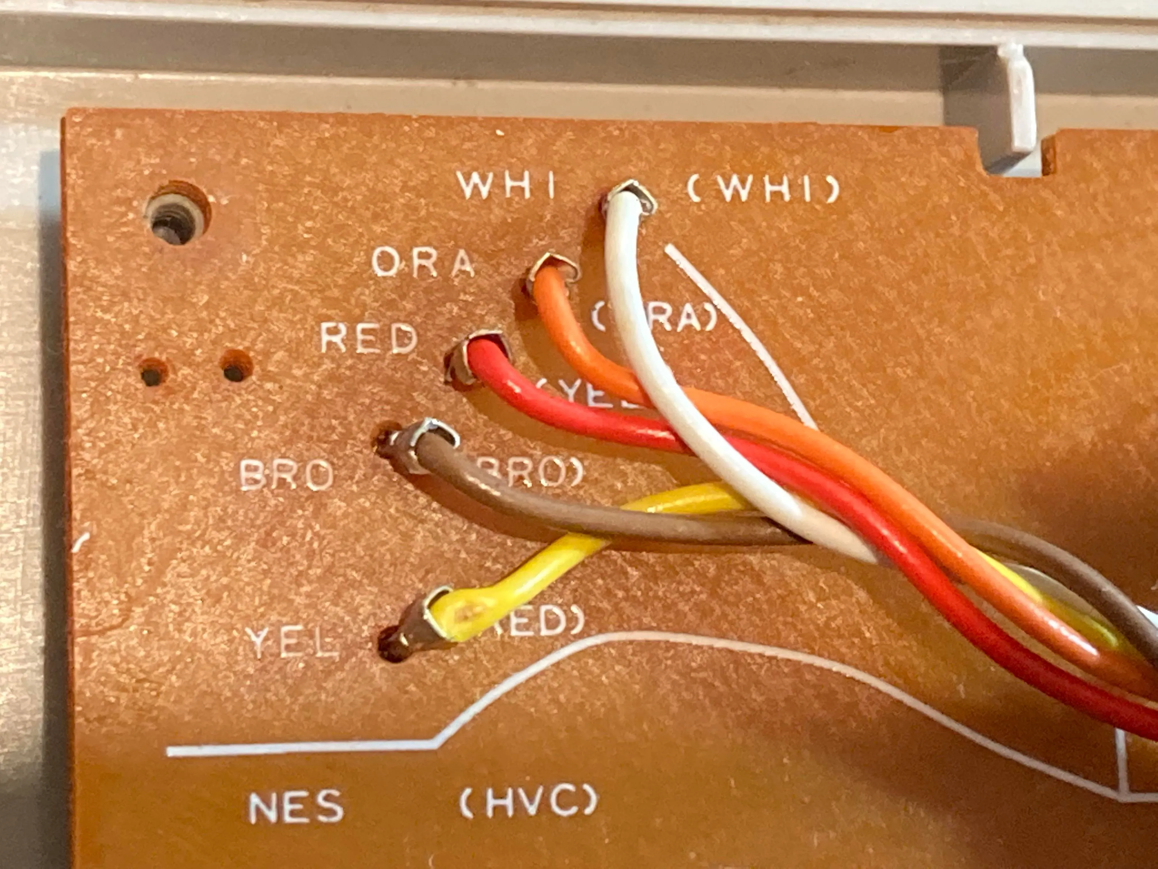 Cận cảnh các điểm kết nối dây cáp màu sắc trên bảng mạch PCB của tay cầm NES, hiển thị 5 dây tín hiệu và nguồn.