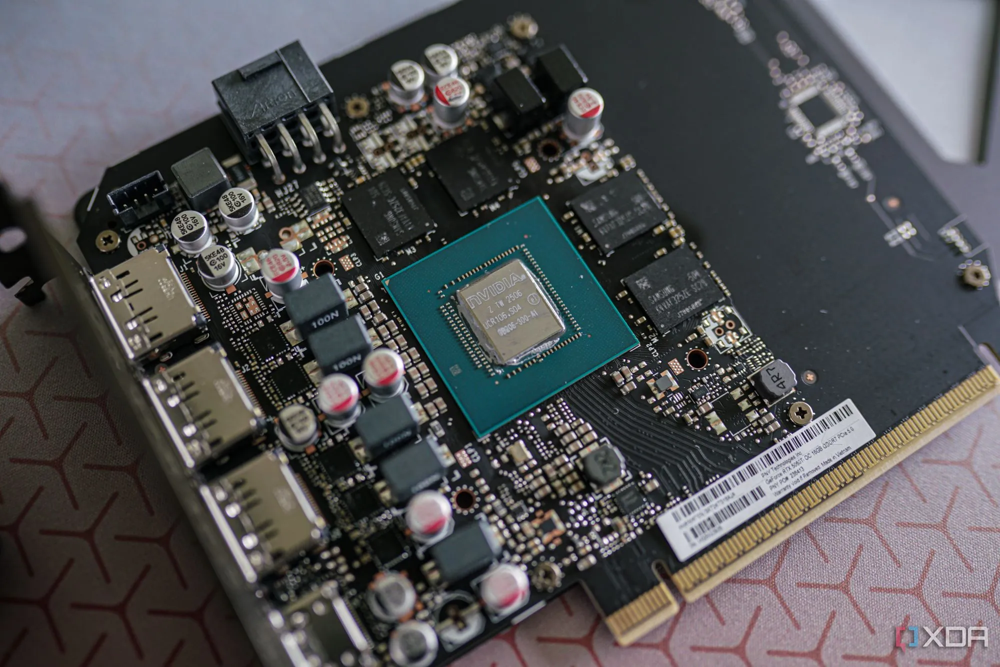 Cận cảnh card đồ họa đã tháo tản nhiệt, hiển thị GPU die, chip nhớ và các miếng thermal pad trên PCB