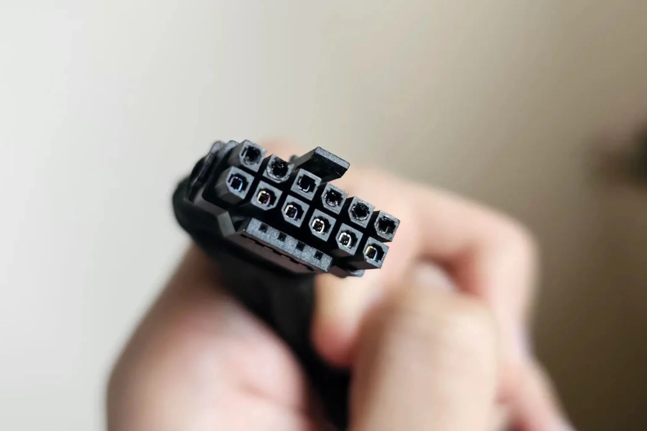 Cáp nguồn 12VHPWR bị cháy xém cầm trên tay, minh họa lỗi cáp nóng chảy của card đồ họa RTX.