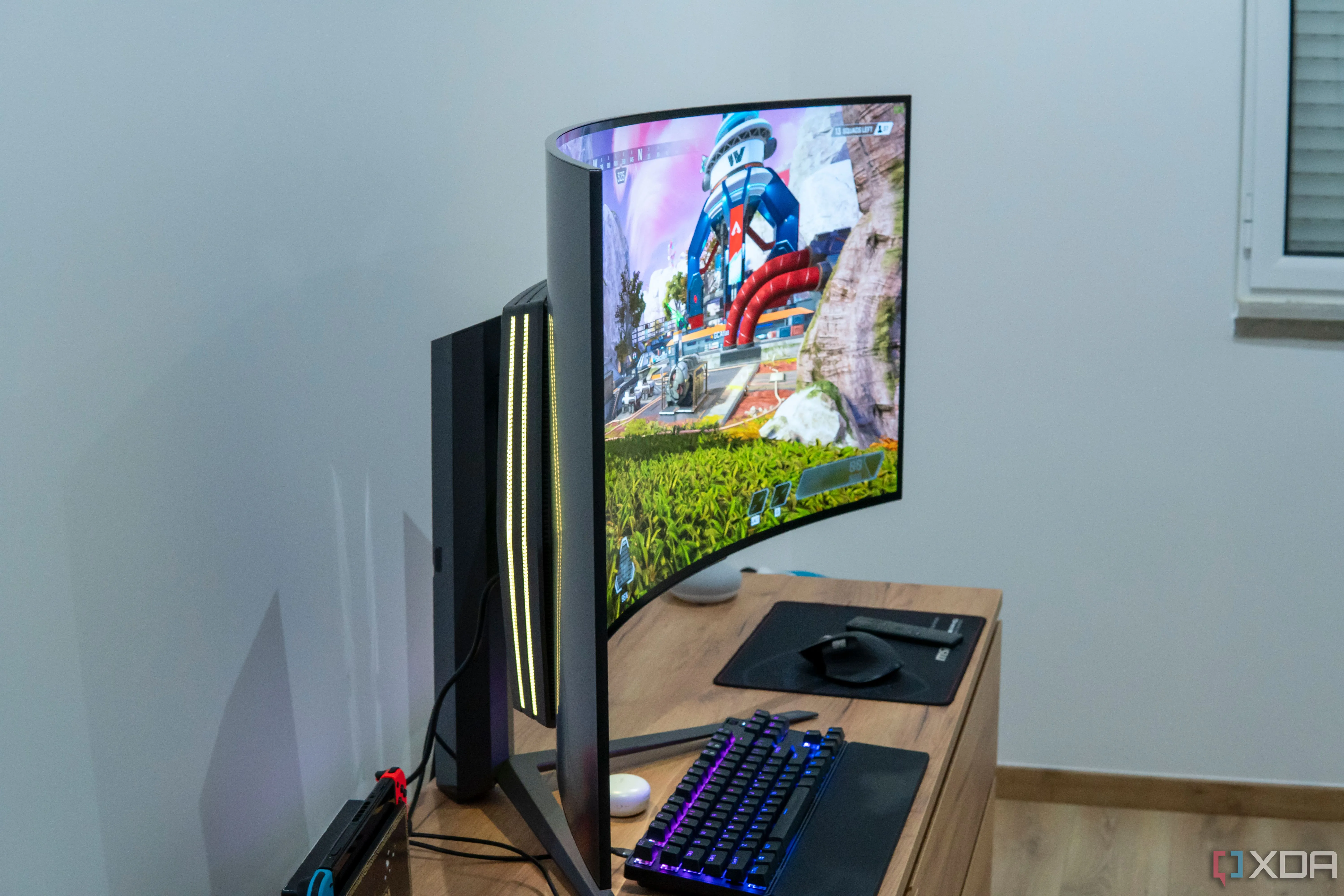 Góc nhìn cạnh bên của màn hình LG UltraGear 45GR95QE với đèn RGB chiếu sáng, đang hiển thị cảnh game Apex Legends.