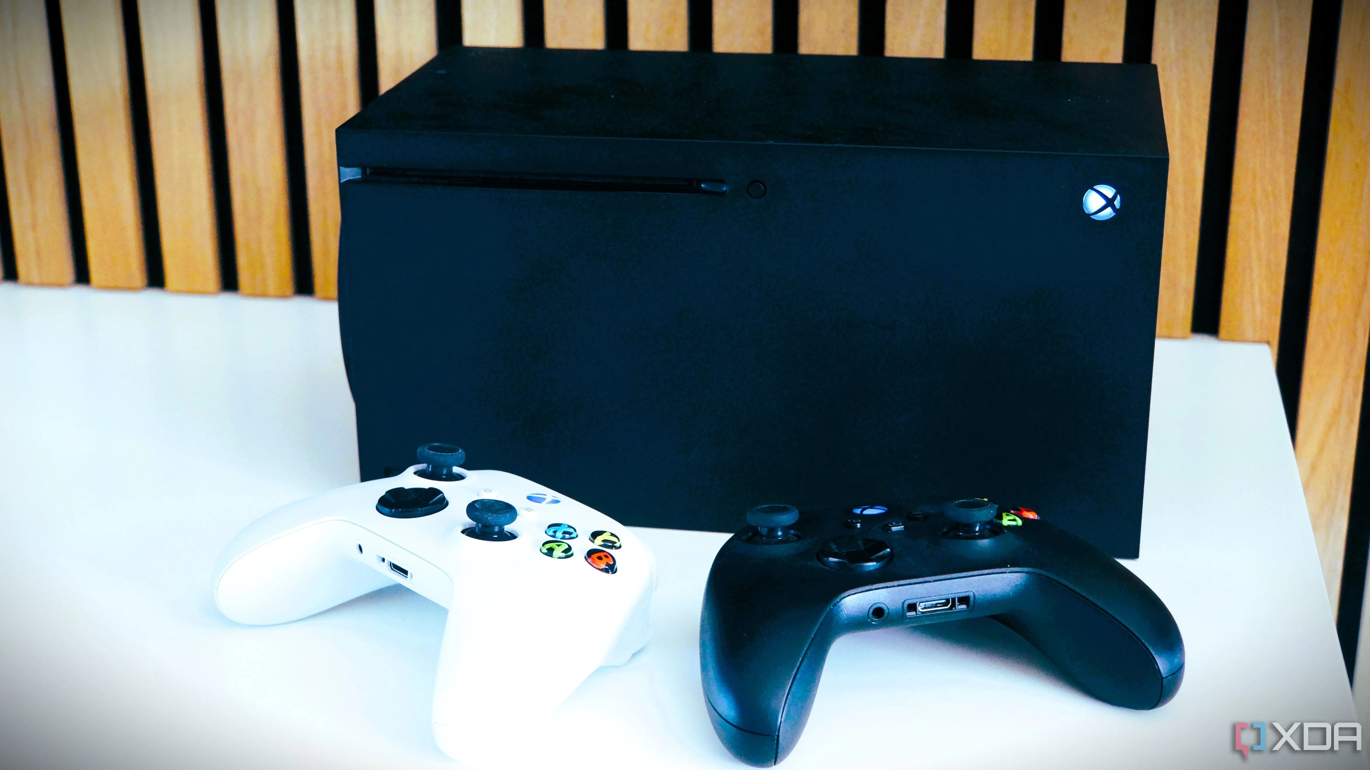 Hai tay cầm Xbox trước console Xbox Series X, minh họa việc tăng giá thiết bị chơi game