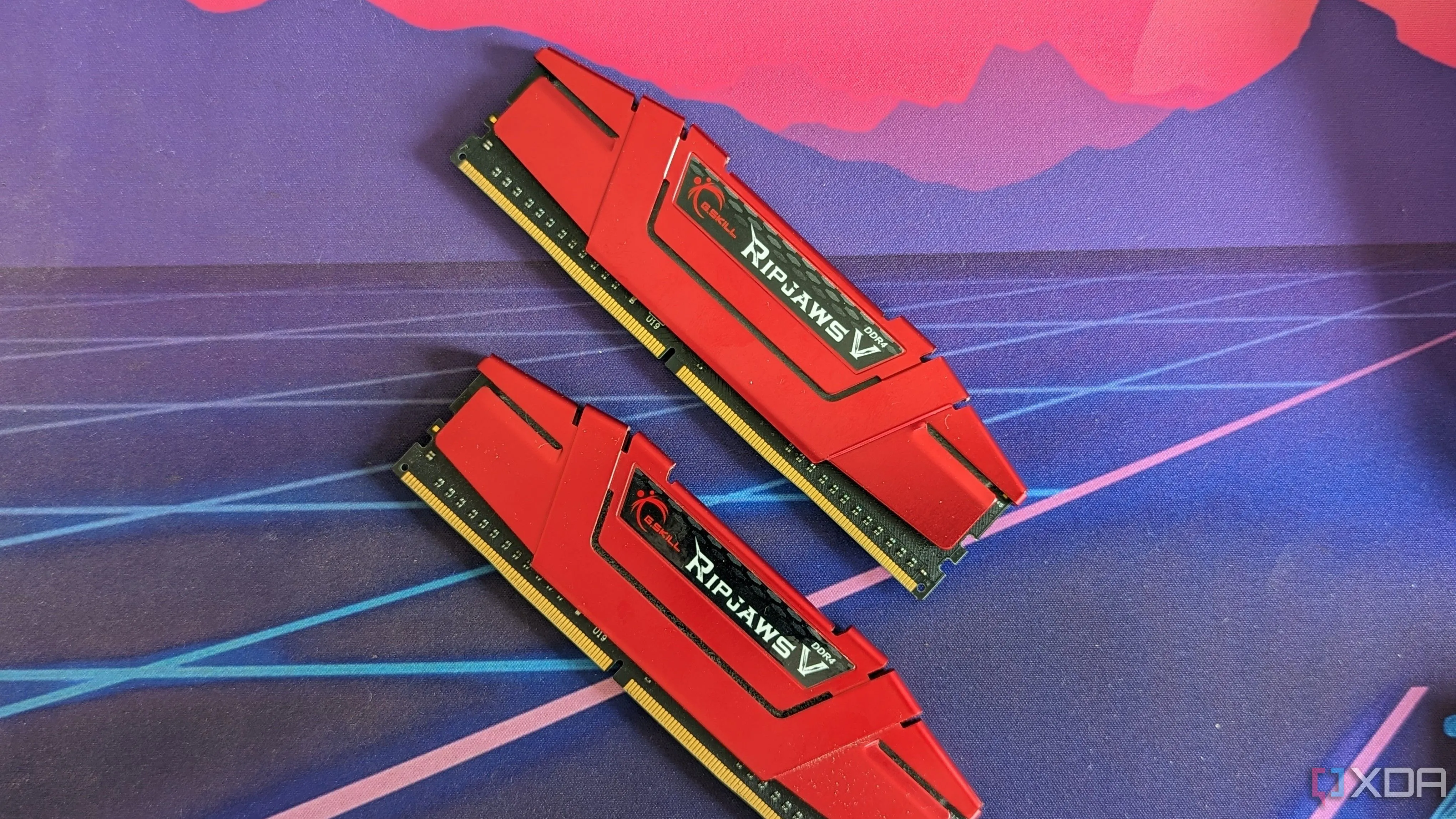 Hai thanh RAM G.Skill Ripjaws DDR4 màu đỏ trên bàn làm việc, minh họa cho việc cần kích hoạt XMP