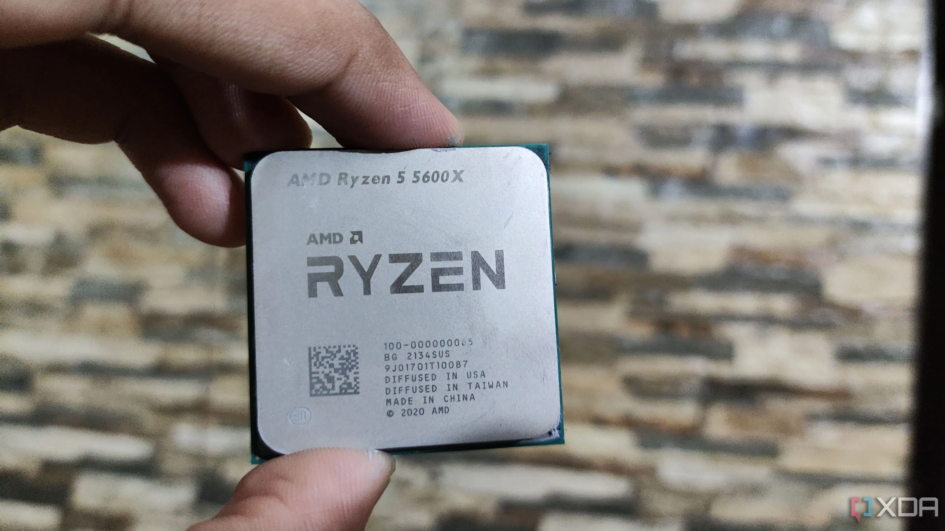 Hình ảnh một người đang cầm chip CPU AMD Ryzen 5 5600X