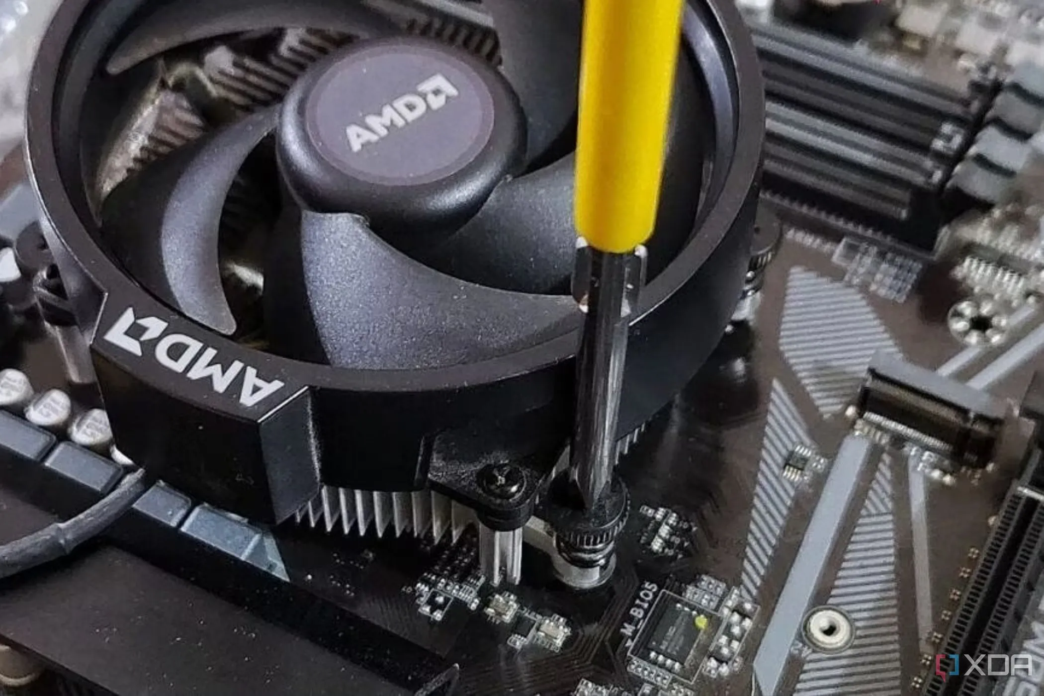Lắp đặt tản nhiệt CPU AMD vào bo mạch chủ bằng tua vít.
