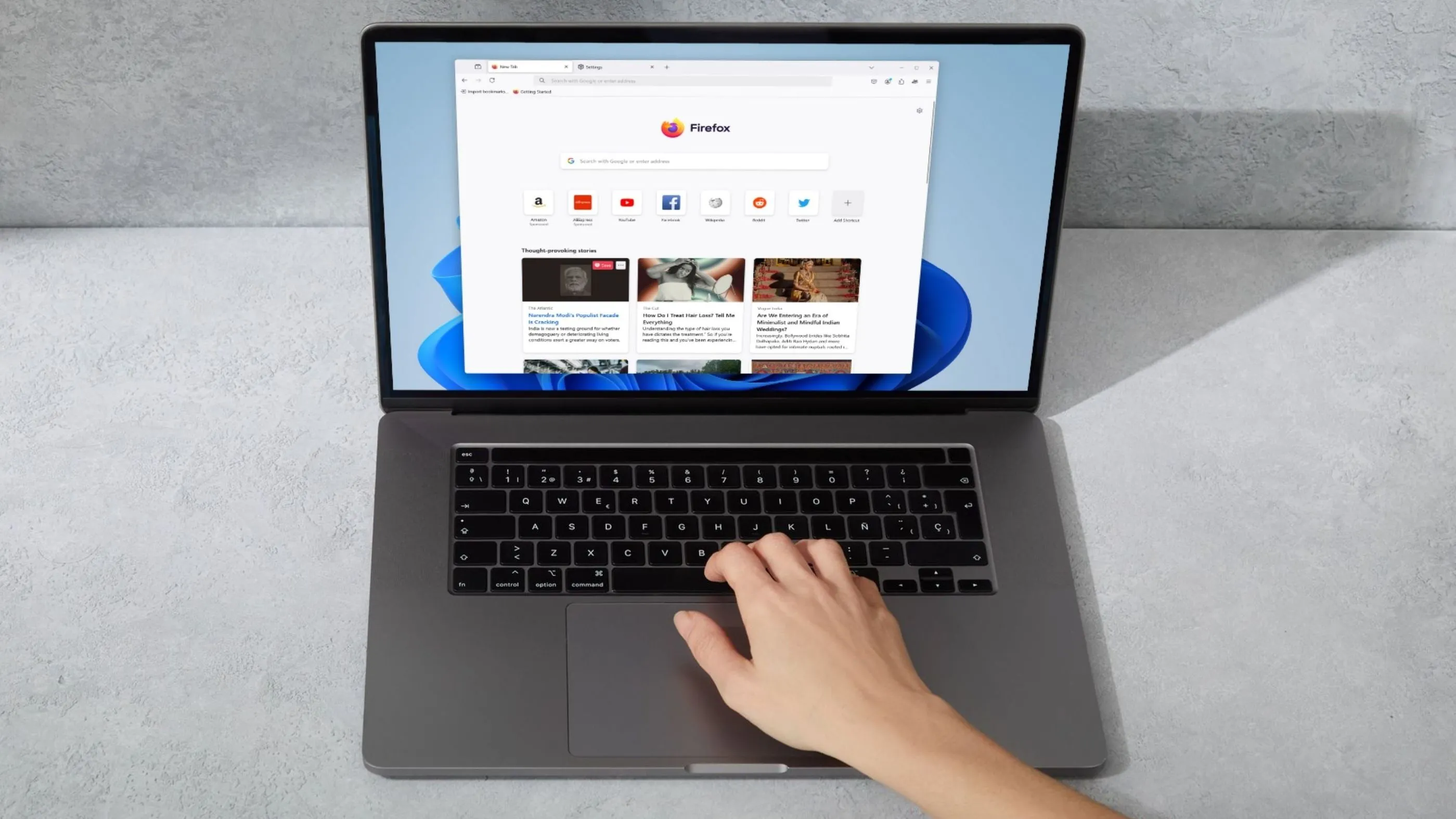 Laptop với Firefox trên màn hình và bàn tay đang gõ bàn phím