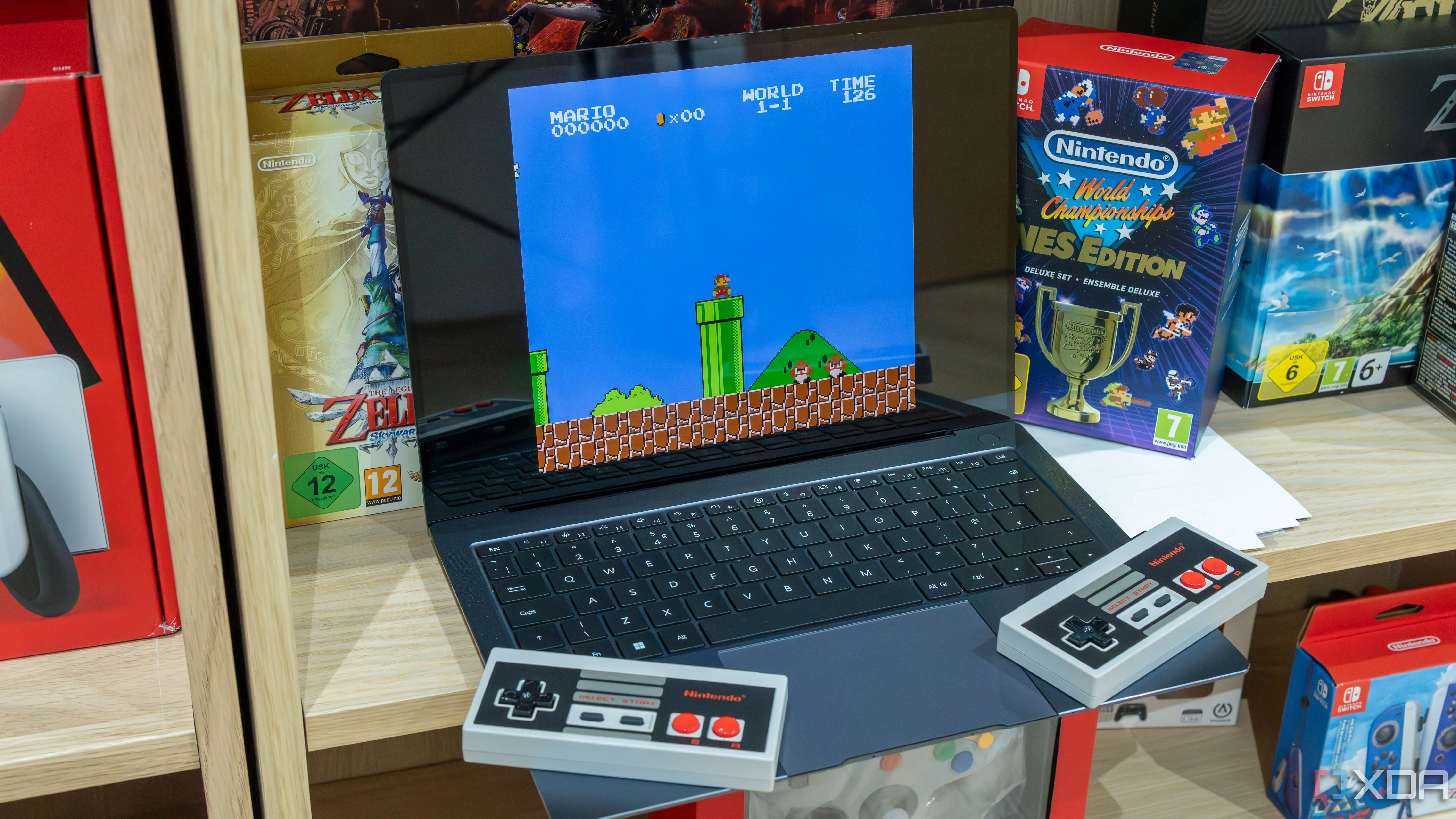 Laptop Windows 11 đang chạy giả lập game Super Mario Bros cùng hai tay cầm NES không dây