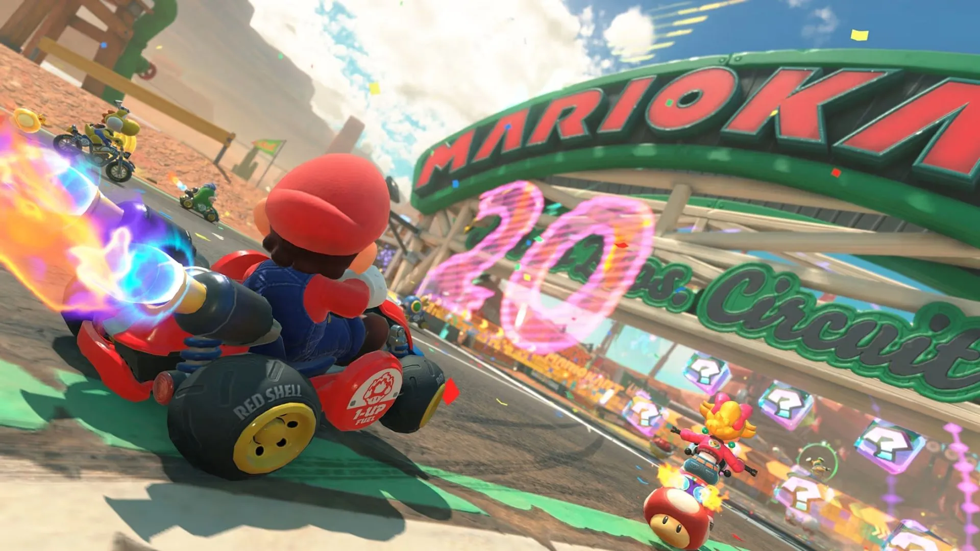 Mario Kart World hình ảnh báo chí 5: Các nhân vật đua xe qua một cây cầu lớn, thể hiện yếu tố mở của đường đua