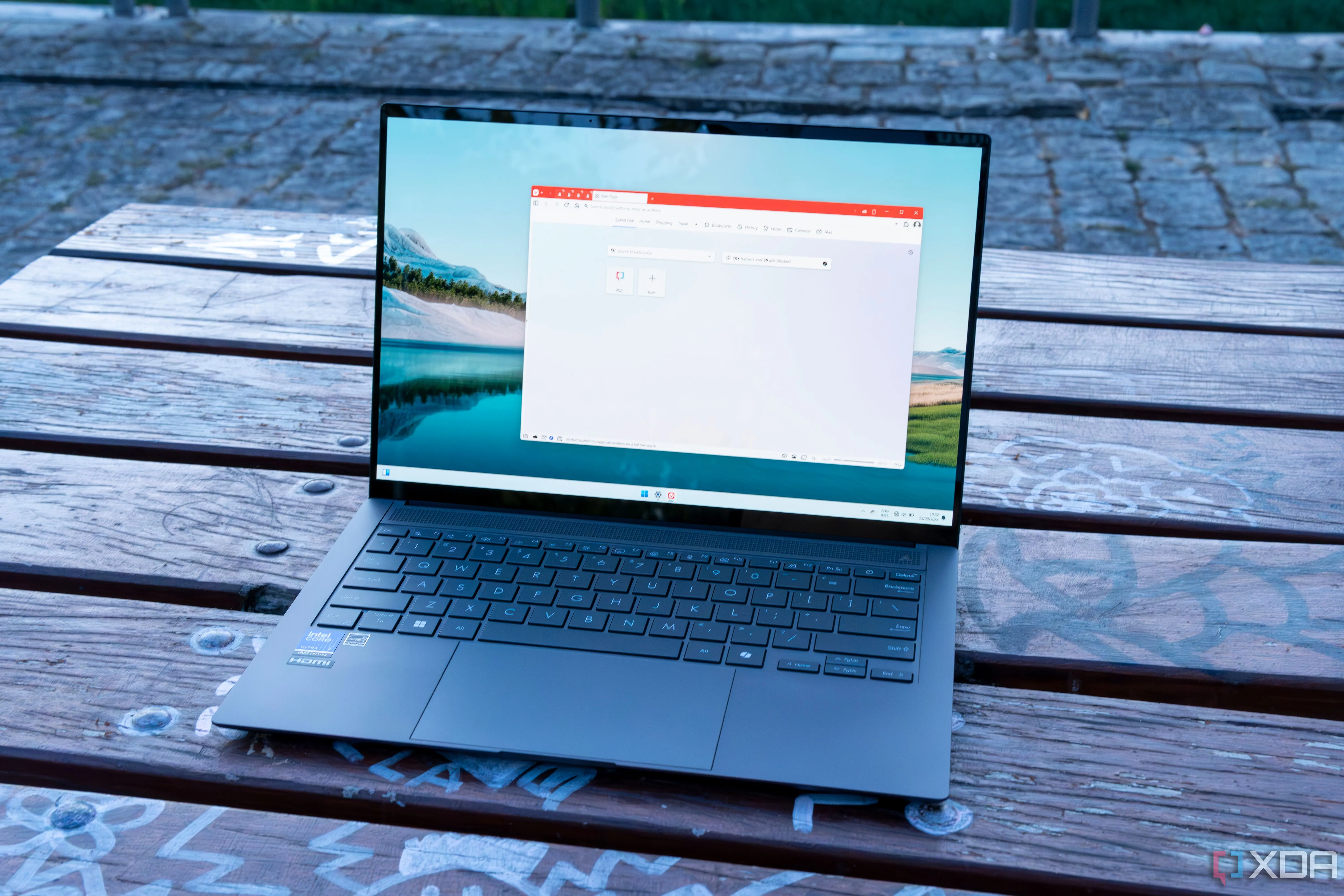 Mặt trước nghiêng của Asus Zenbook S 14 hiển thị trang chủ trình duyệt Vivaldi trên nền desktop Windows 11