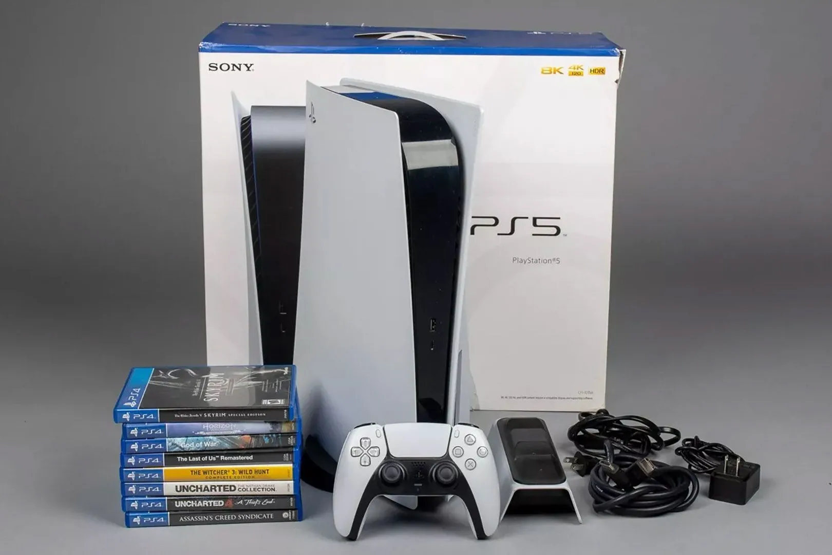 Máy console PlayStation 5 đặt cạnh một chồng vỏ game, minh họa thư viện game độc quyền PS5 đa dạng và phong phú