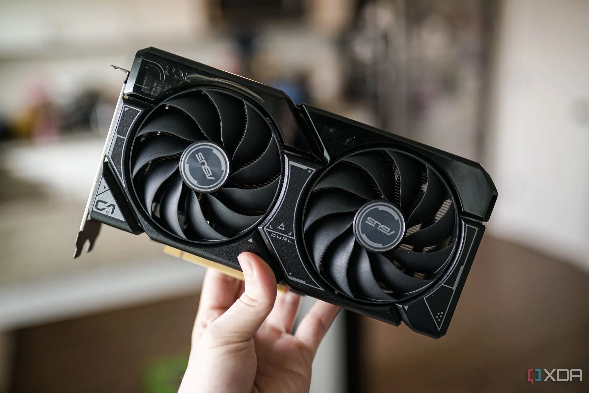 Một bàn tay đang cầm card đồ họa Nvidia RTX 4060, một GPU 8GB VRAM phổ biến trên thị trường.