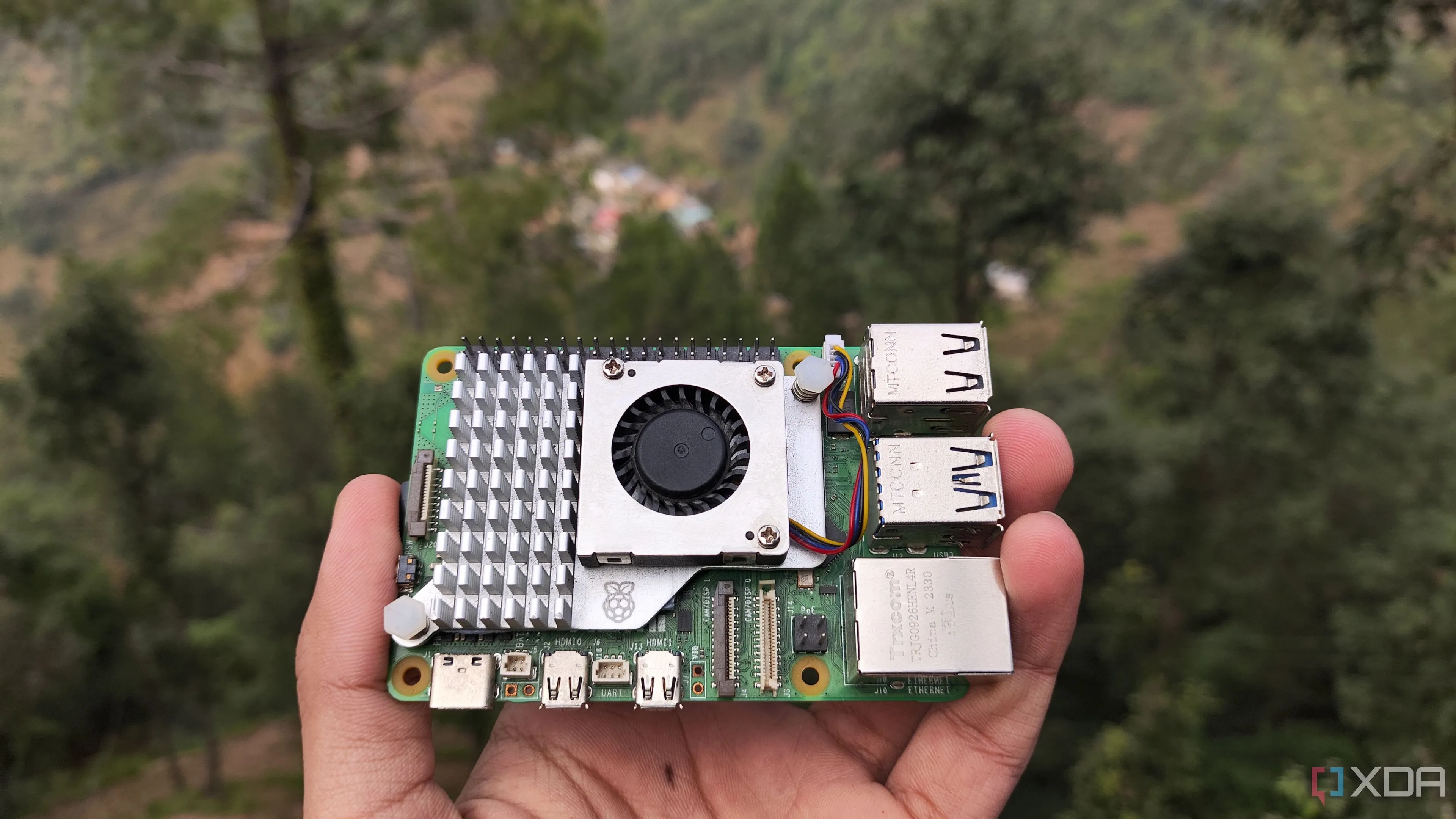 Một người đang cầm máy tính bảng đơn Raspberry Pi 5, thiết bị phổ biến để chạy Pi-hole