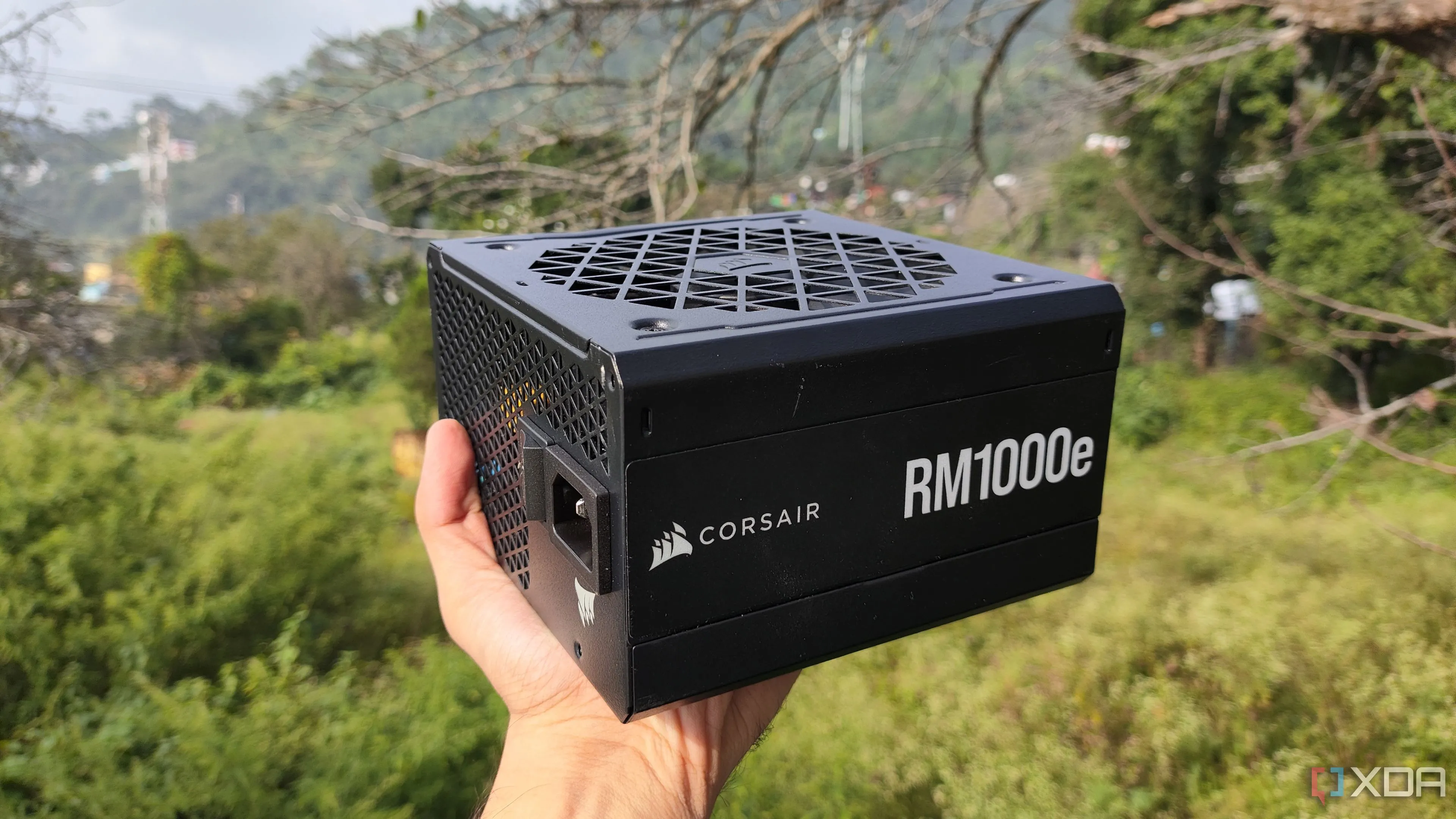 Người dùng cầm nguồn máy tính Corsair RM1000e, minh họa PSU chất lượng cao