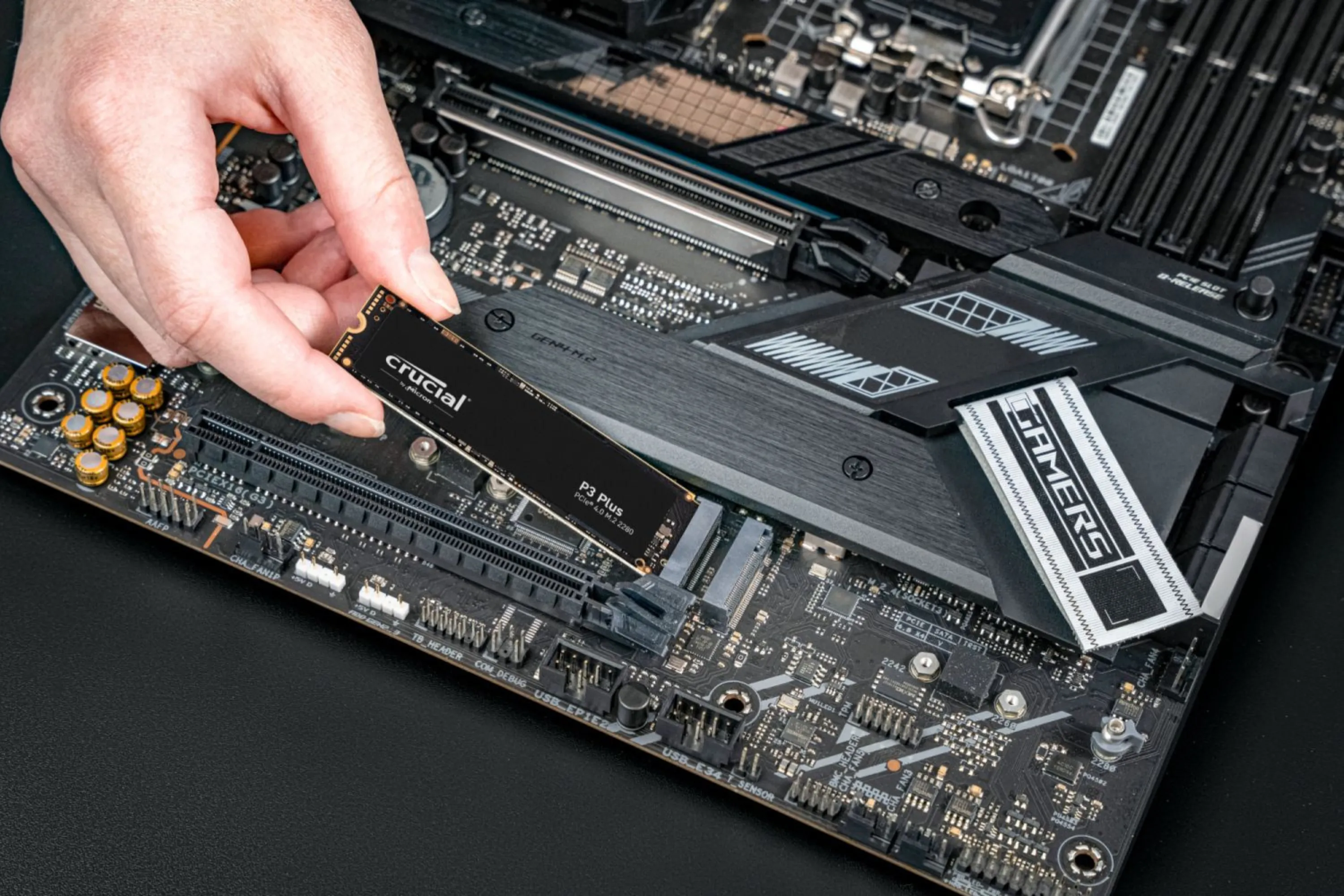 Quá trình lắp đặt SSD NVMe Crucial P3 Plus PCIe M.2 2280 vào khe cắm trên bo mạch chủ, minh họa cách tránh làm cong SSD