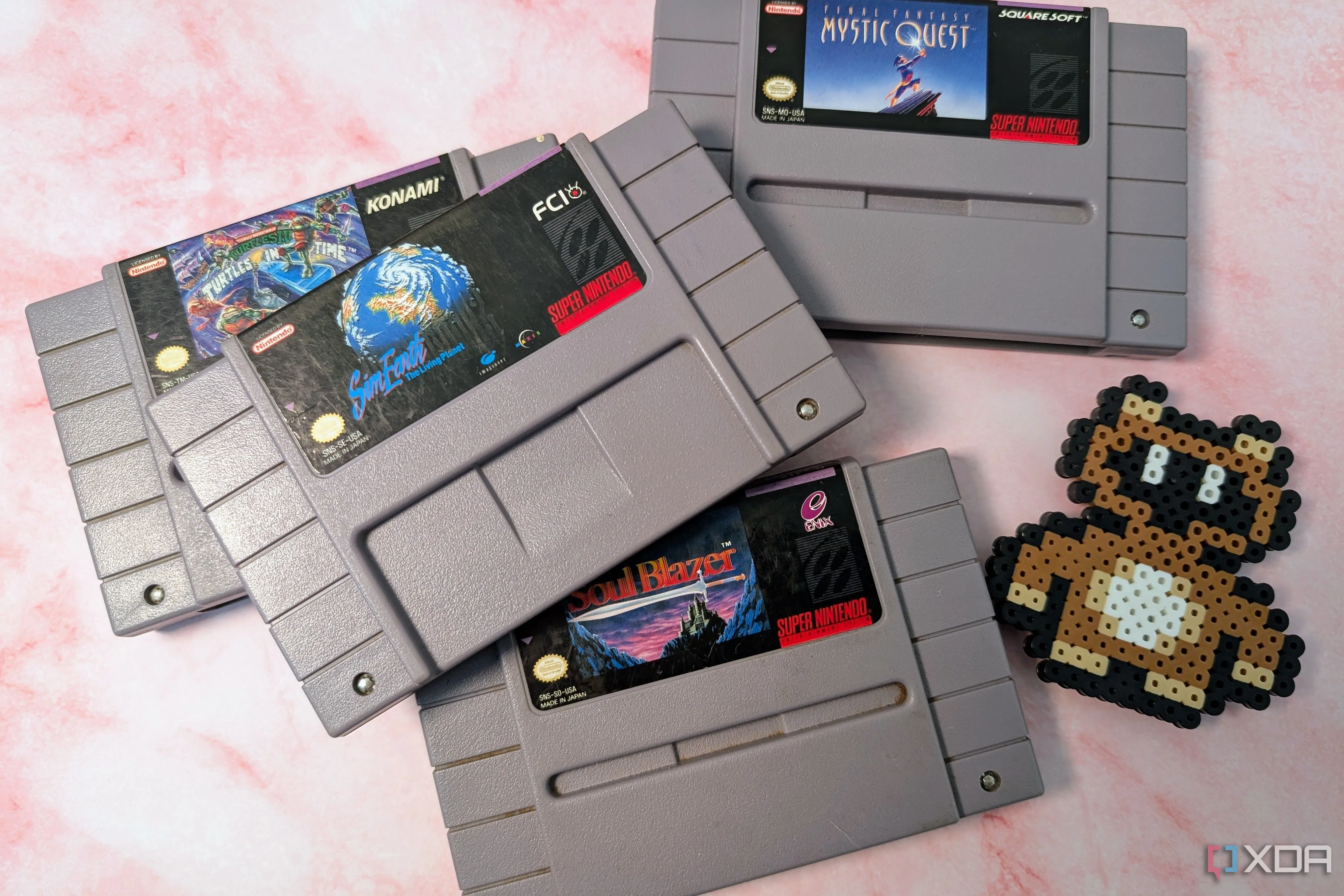 Super Nintendo games SimEarth, Soul Blazer, Mystic Quest, and Turtles in Time next to a Tankui suit