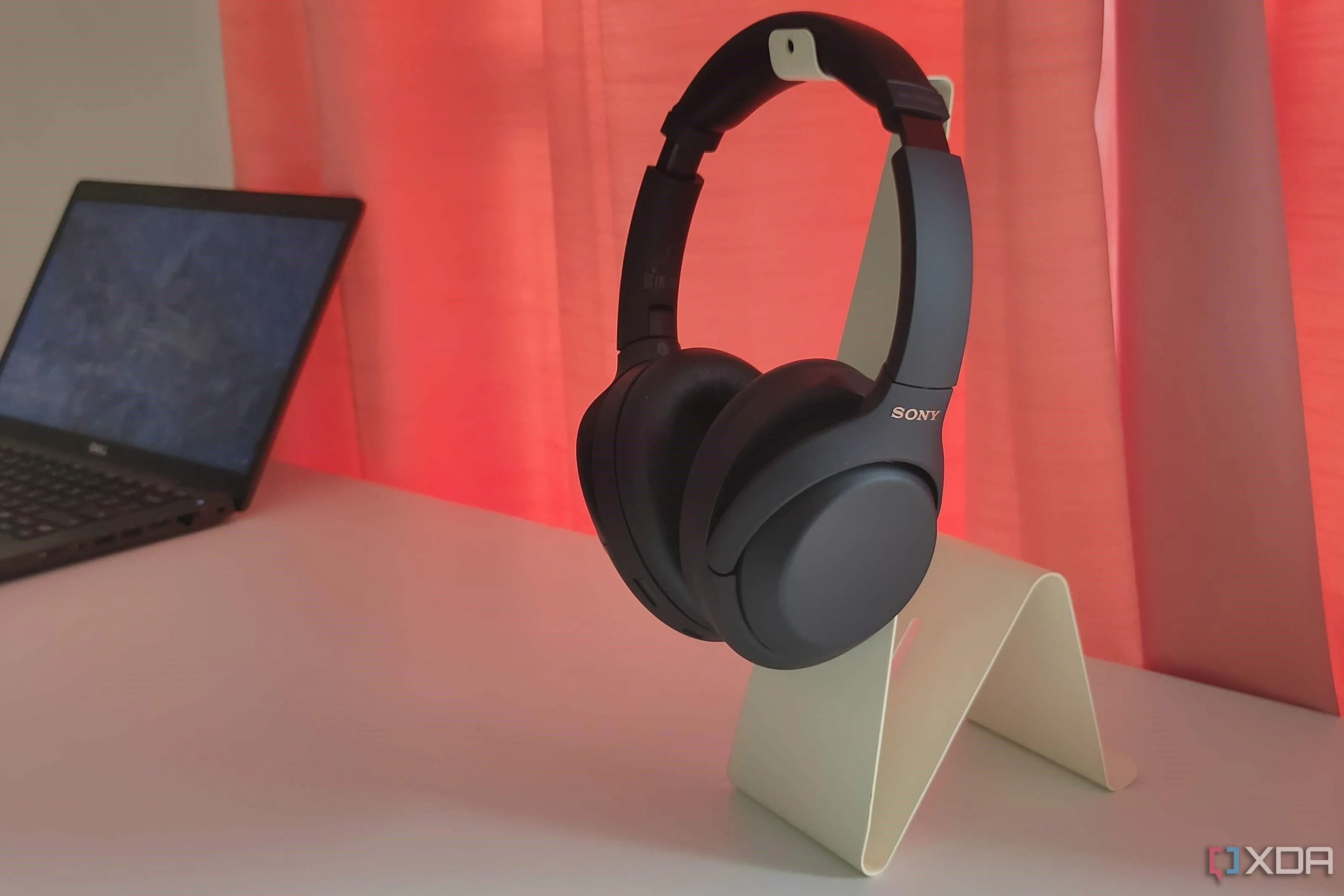 Tai nghe Sony WH-1000XM4 màu đen đặt trên giá đỡ màu trắng.