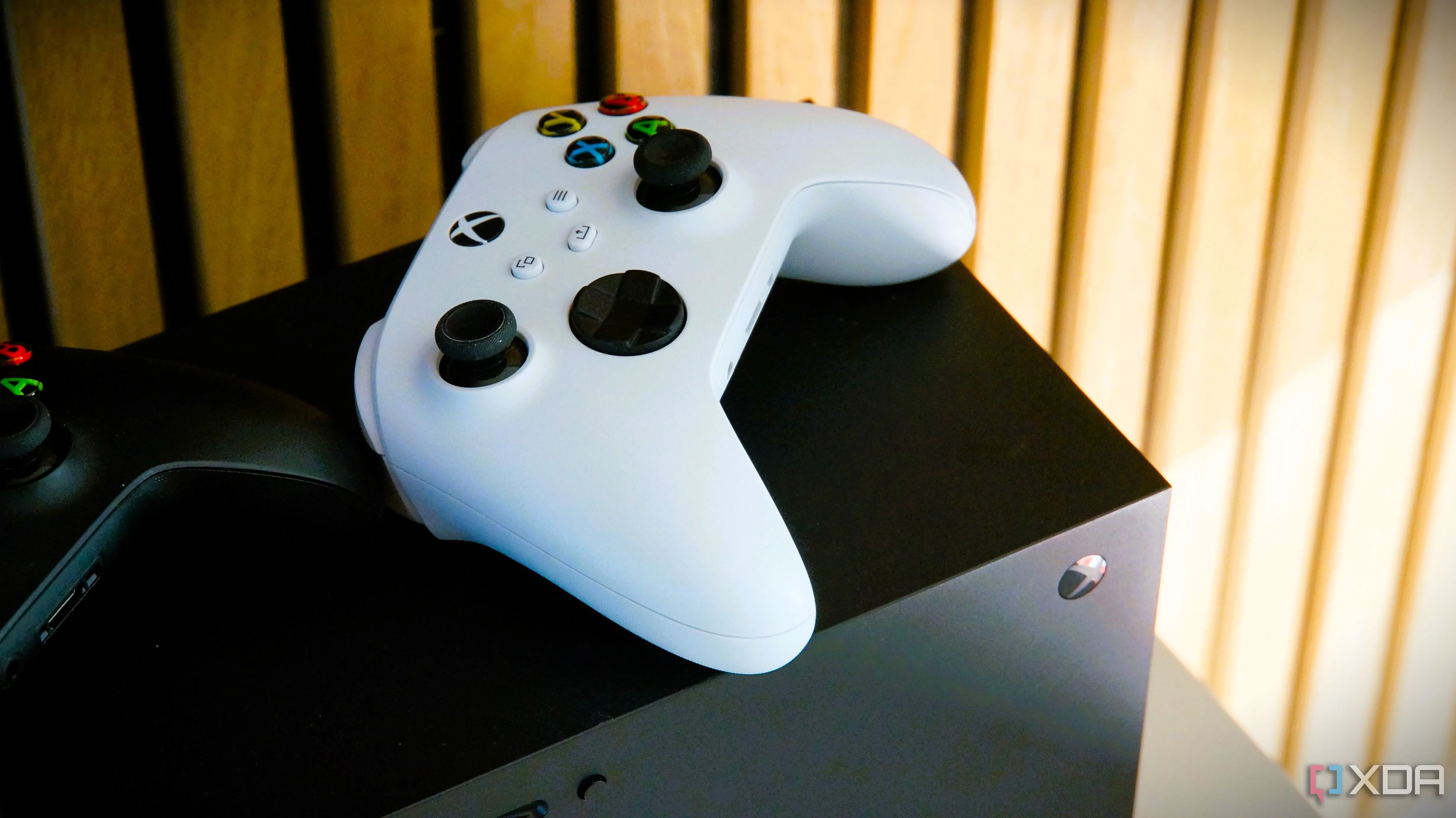 Tay cầm Xbox Series X màu trắng đặt trên console, biểu tượng cho sự cạnh tranh giữa PC và console gaming