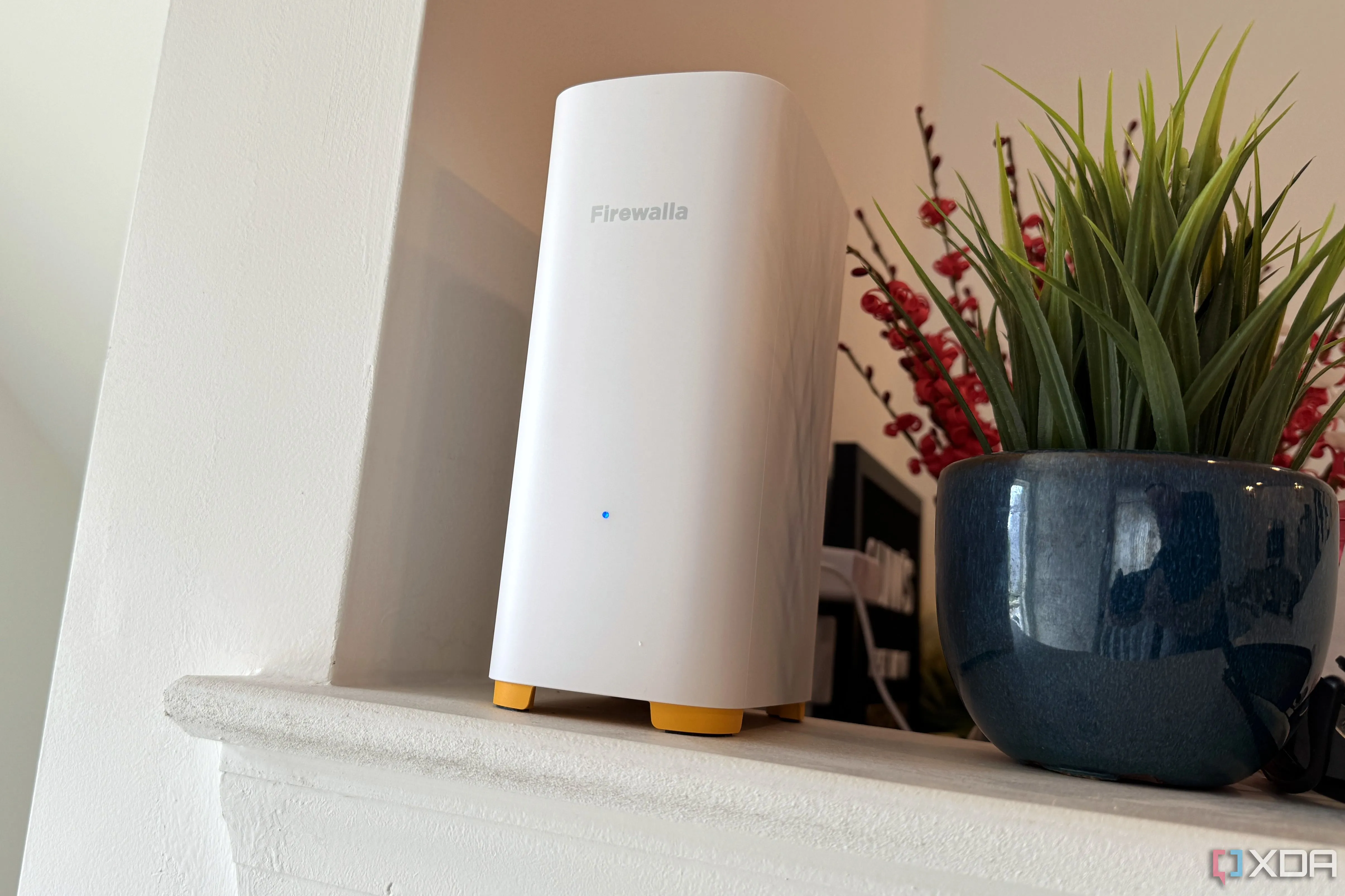 Thiết bị Access Point Firewalla AP7 Wi-Fi 7 đặt trên bàn cạnh chậu cây, thể hiện thiết kế tinh tế