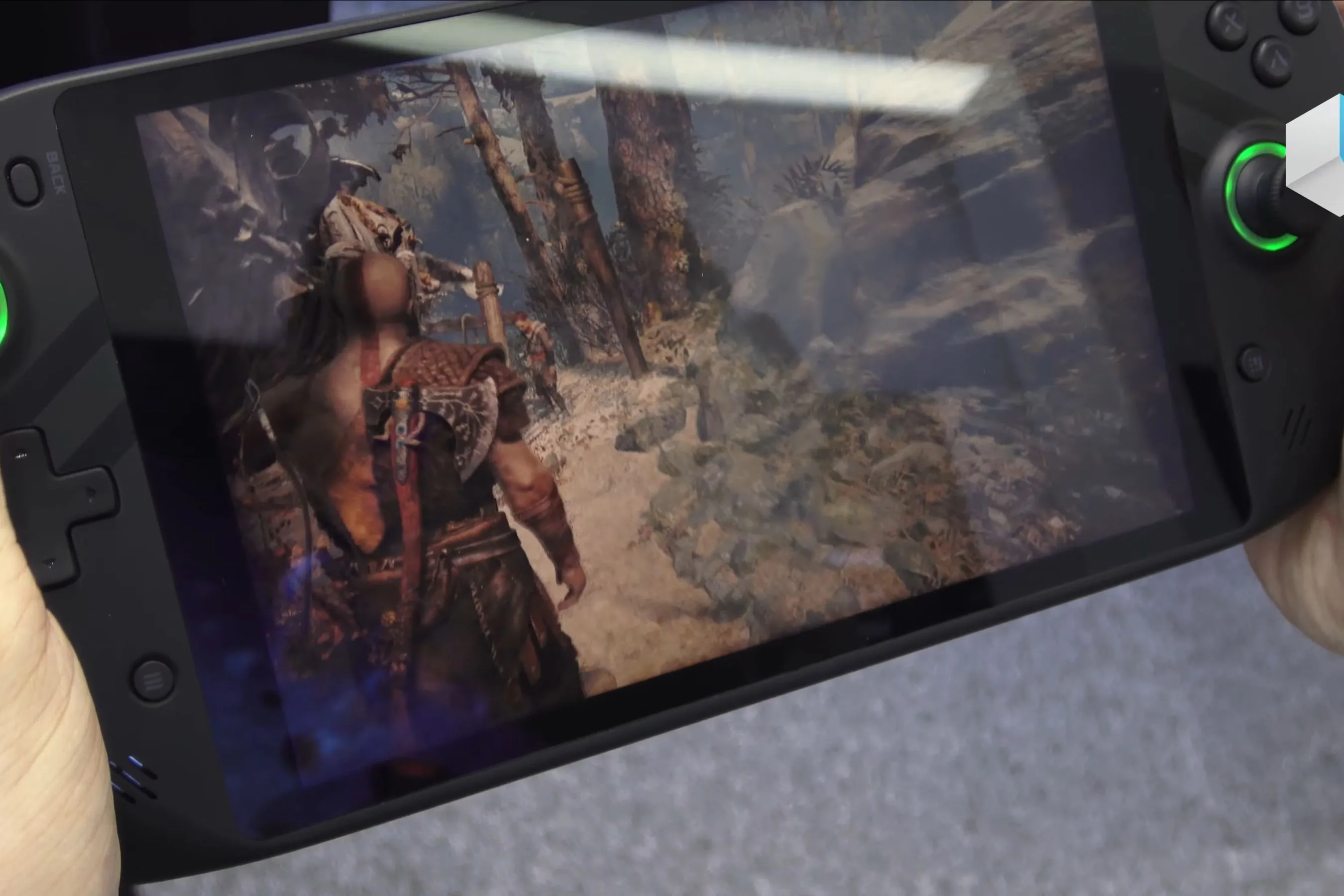 Thiết bị chơi game cầm tay Emdoor hiển thị game God of War, minh họa trải nghiệm game AAA trên màn hình di động.