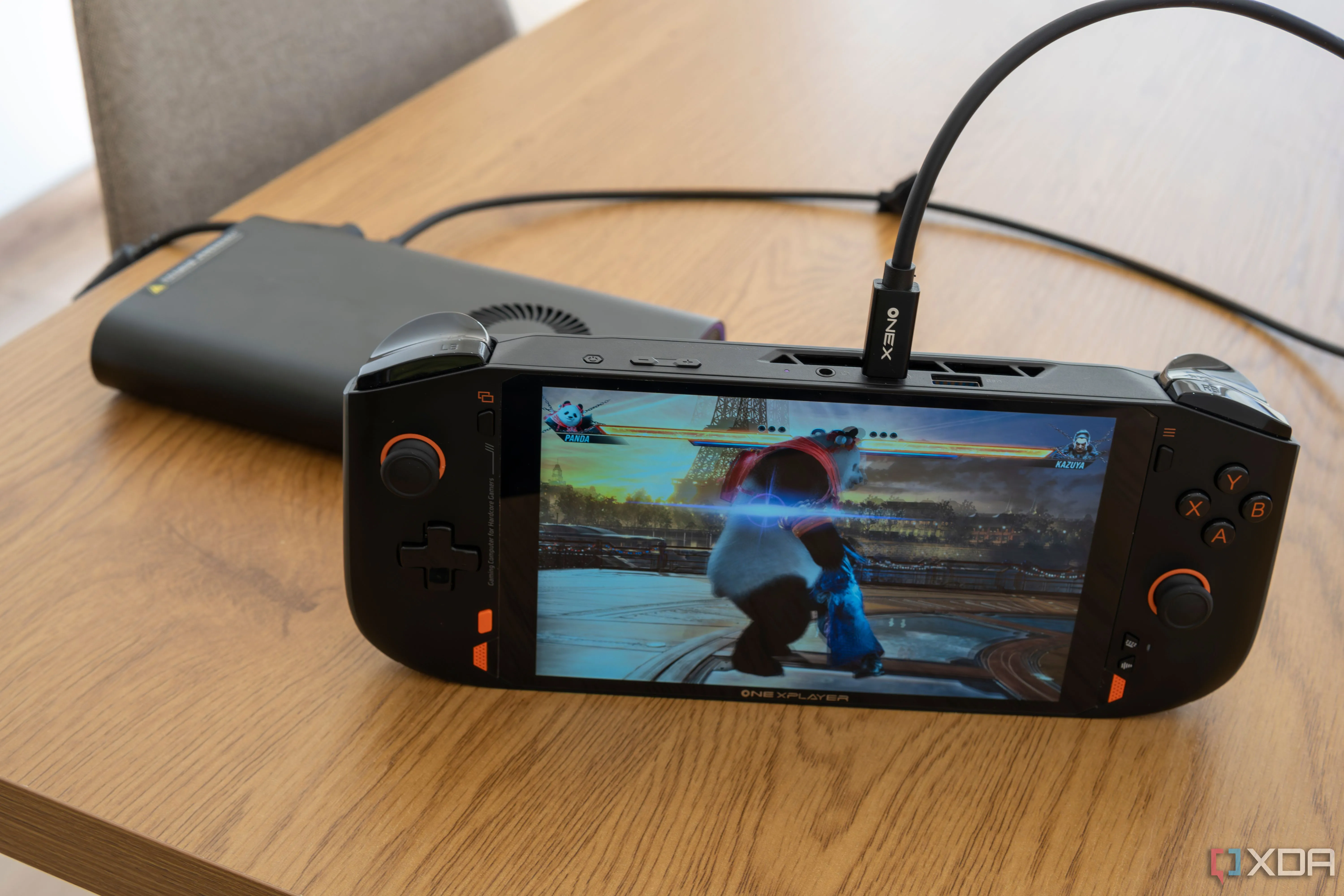 Thiết bị chơi game cầm tay One XPlayer Mini Pro đang chạy game Tekken 8, kết nối với eGPU OneXGPU qua OCuLink để tăng cường hiệu năng đồ họa