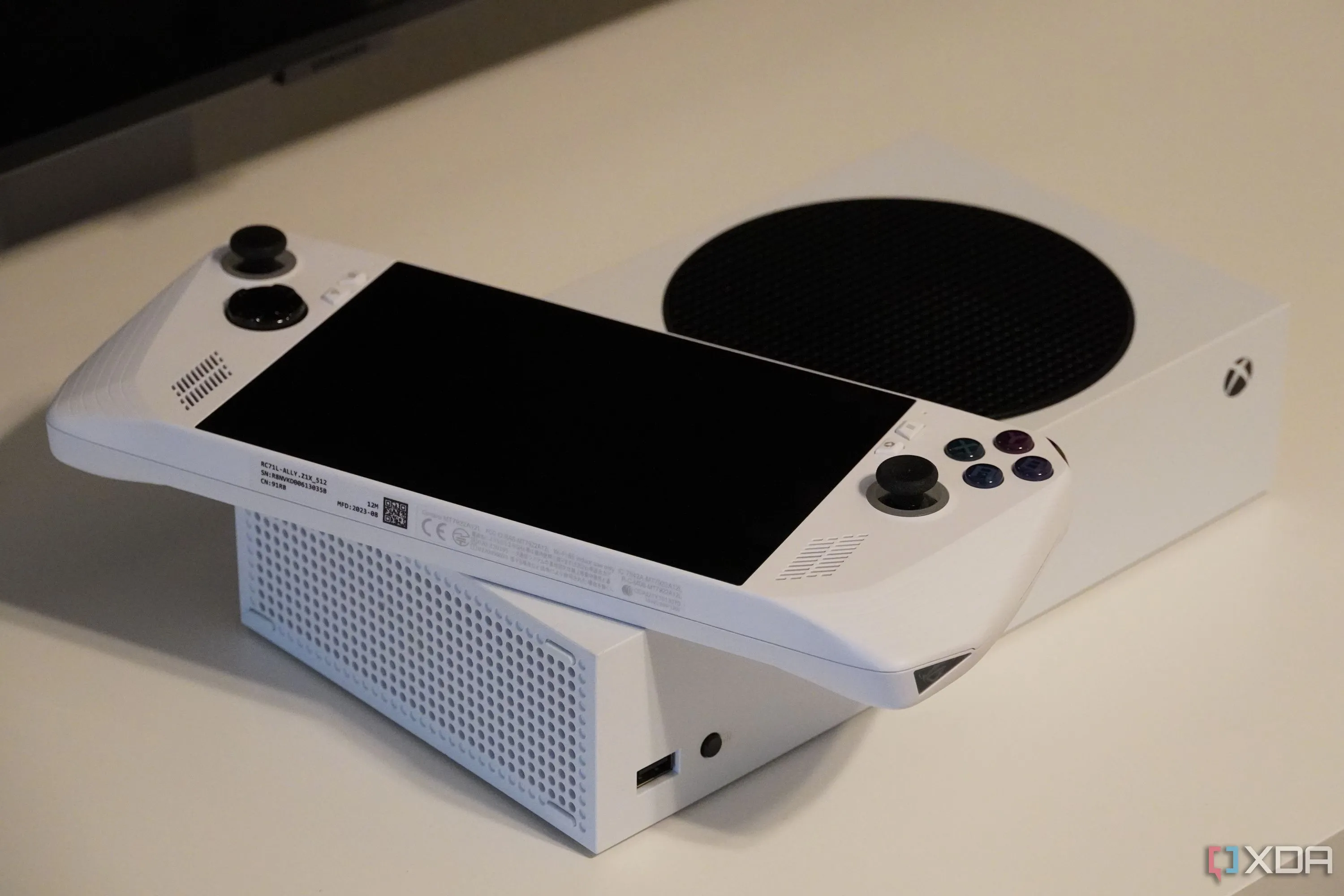 Thiết bị chơi game cầm tay ROG Ally đặt trên đầu máy console Xbox Series S