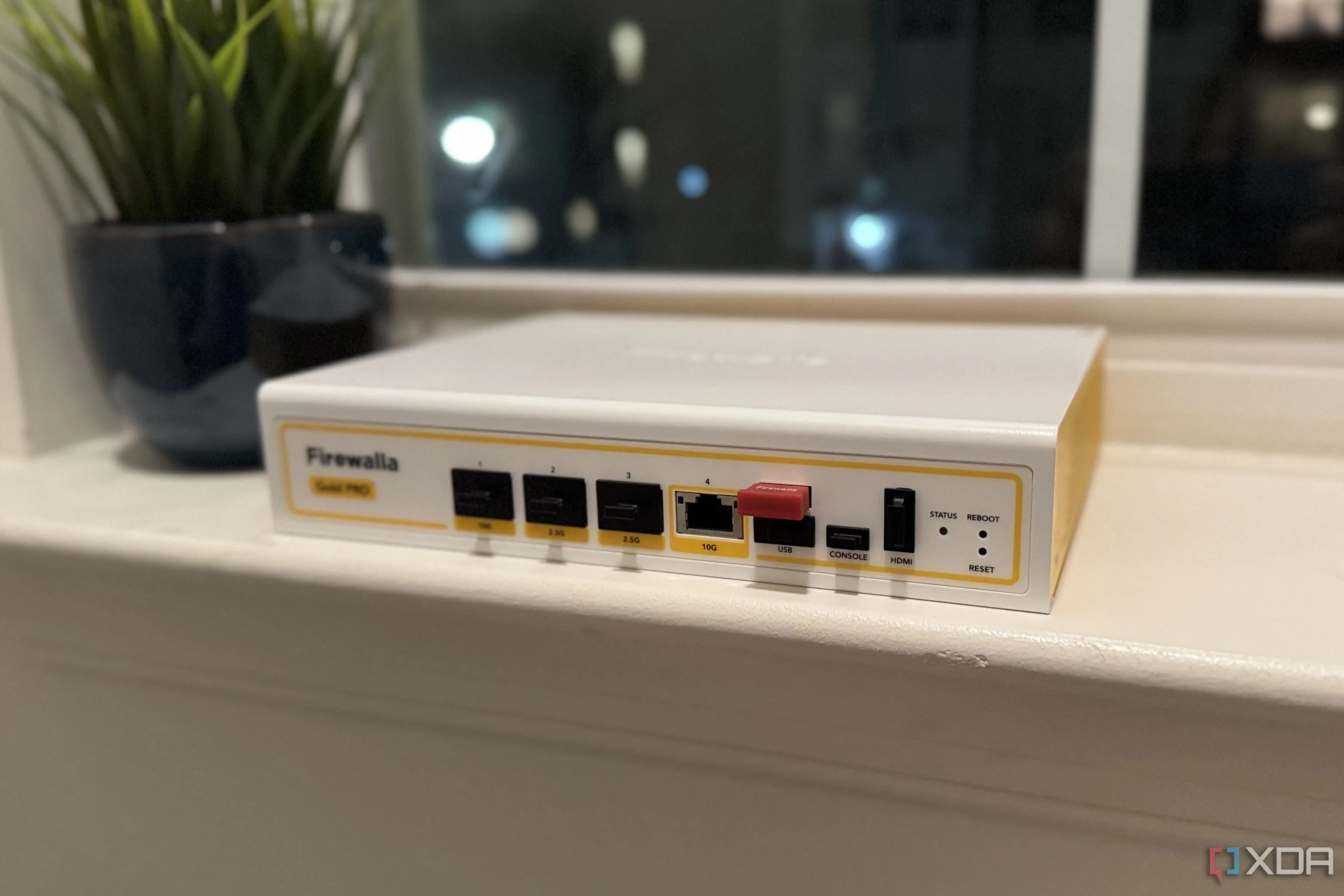 Thiết bị tường lửa phần cứng Firewalla Gold Pro trên bệ cửa sổ, nhấn mạnh tầm quan trọng của firewall trong bảo mật mạng IoT.